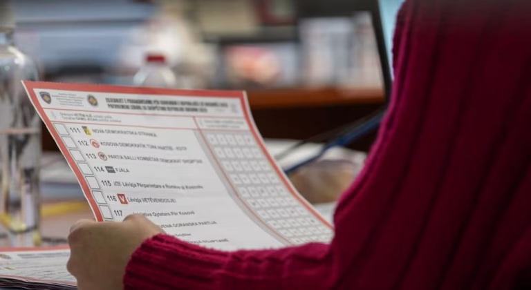 Një zyrtare e Komisionit Qendror Zgjedhor duke mbajtur në dorë një fletëvotim gjatë rinumërimit të votave për zgjedhjet e parakohshme të 28 dhjetorit të hënën e 19 dhjetorit në Prishtinë.